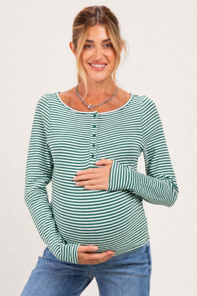 woman wearing a green and white striped maternity top with buttons, showcasing her baby bump