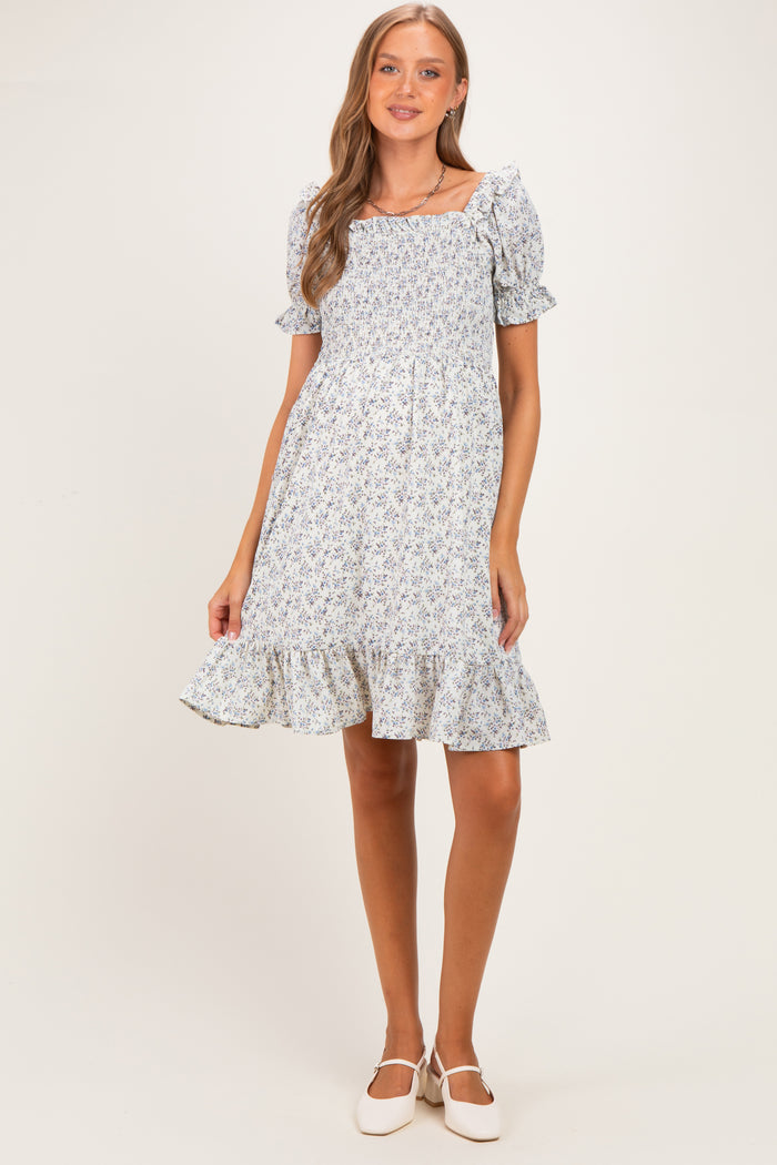 woman wearing a floral print maternity dress with short puff sleeves and a ruffled hem