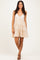 woman wearing a beige tiered sundress with a lace bodice and spaghetti straps