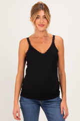 woman wearing a black maternity tank top with lace trim and a visible baby bump