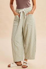woman wearing green and white gingham wide-leg pants with a drawstring waist and pockets