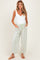 woman wearing a white maternity bodysuit and green gingham wide-leg maternity pants with pockets and a tie waist