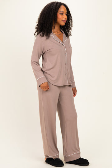 woman wearing a taupe long sleeve button-up pajama set with white piping and matching pants