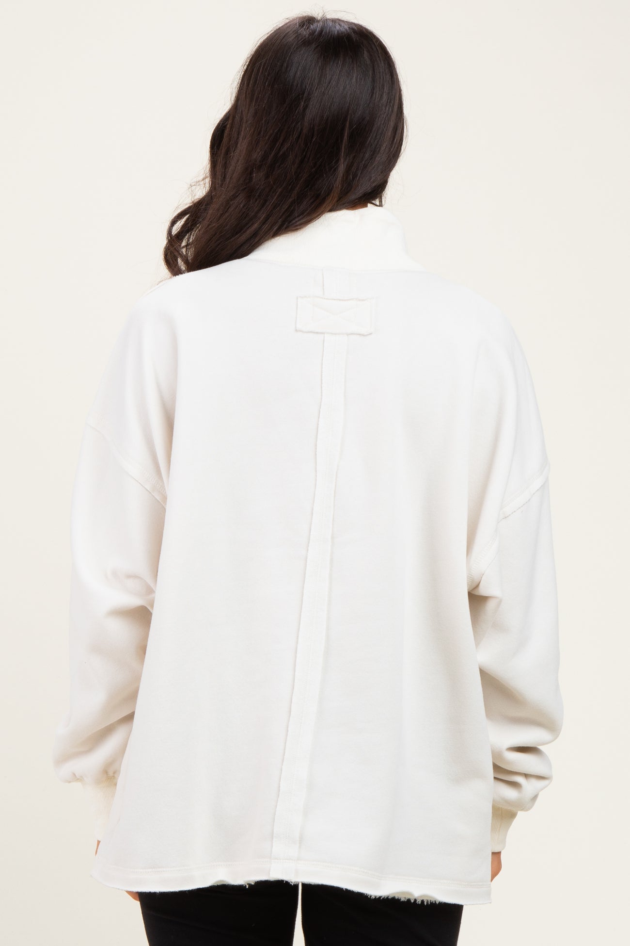woman wearing a relaxed fit white sweatshirt with a back seam detail and long sleeves