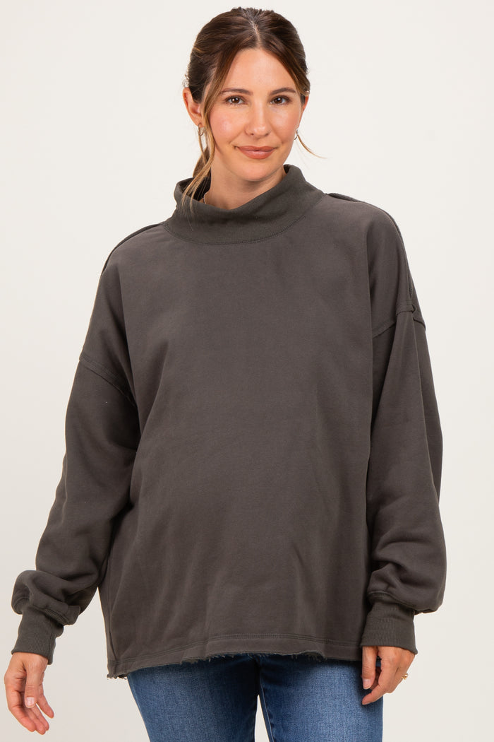 woman wearing a gray oversized maternity sweatshirt with a turtleneck and relaxed fit, showing a baby bump