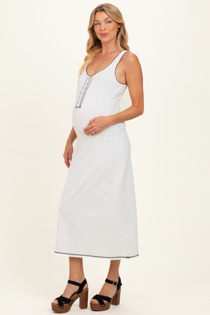 woman wearing a light gray maternity maxi dress with a scoop neckline and button details, highlighting her baby bump