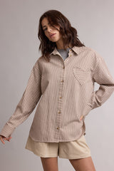 woman wearing a brown and beige striped button-up shirt with a heart pocket, paired with beige shorts