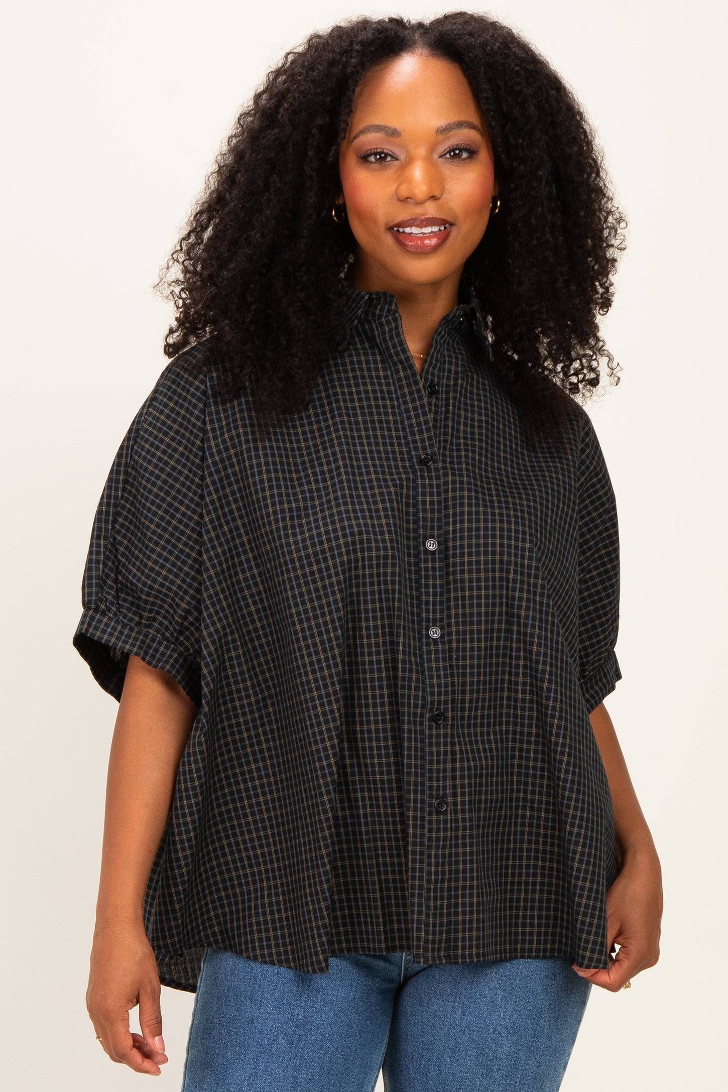 woman wearing a black and blue plaid short sleeve button-up shirt with a relaxed fit and a collar