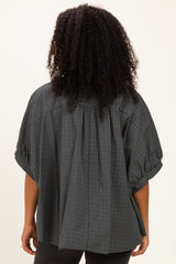 woman wearing a dark green plaid oversized blouse with puff sleeves, shown from the back
