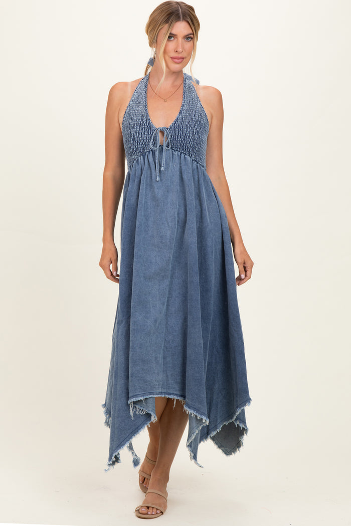 woman wearing a blue denim halter maxi dress with a smocked bodice and frayed hem