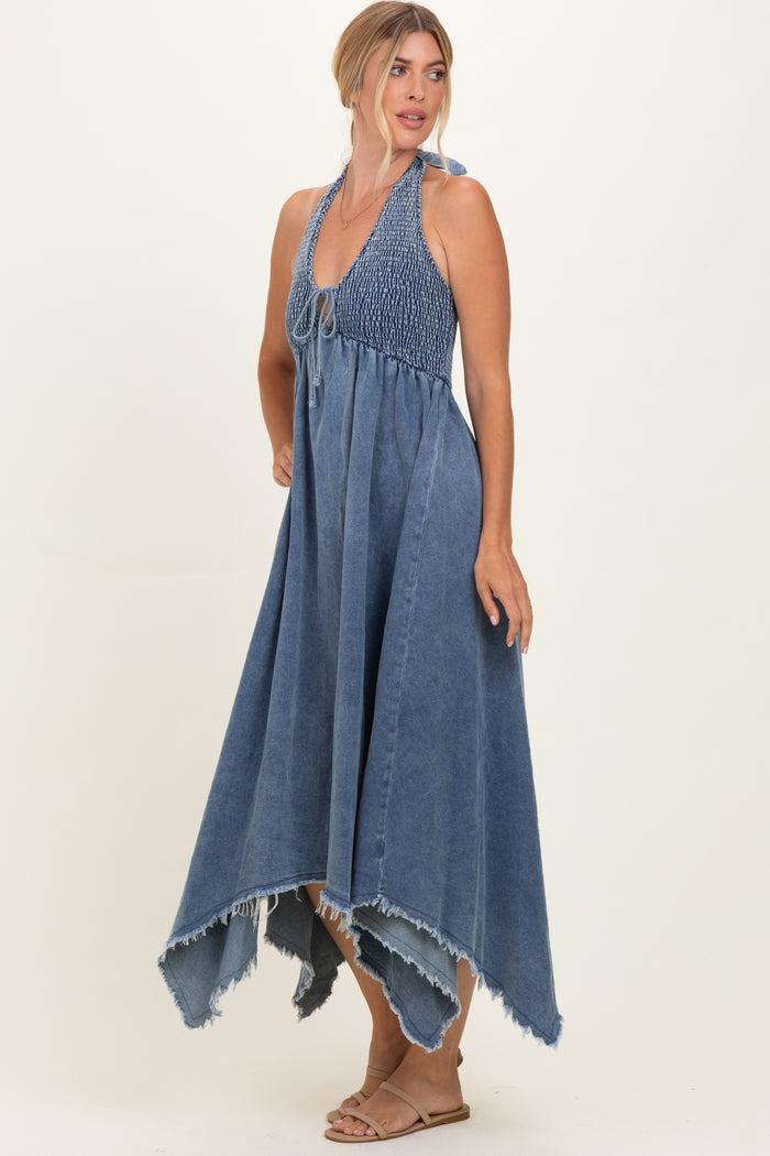 woman wearing a denim blue halter maxi dress with a smocked bodice and raw hem details