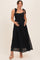woman wearing a black lace maternity maxi dress with tie shoulder straps and cradling her baby bump