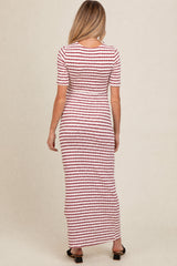 woman wearing a striped red and white long sleeve maternity dress, viewed from the back