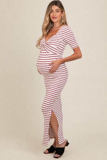 woman wearing a striped maternity maxi dress with a knot detail and side slit, showing her baby bump