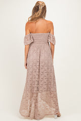 woman wearing a pink off-the-shoulder lace maternity maxi dress, showing a smocked bodice and flowy skirt from the back