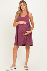 woman wearing a maroon striped maternity dress and holding her baby bump