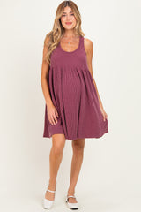 woman wearing a burgundy striped maternity dress with a loose fit and sleeveless design