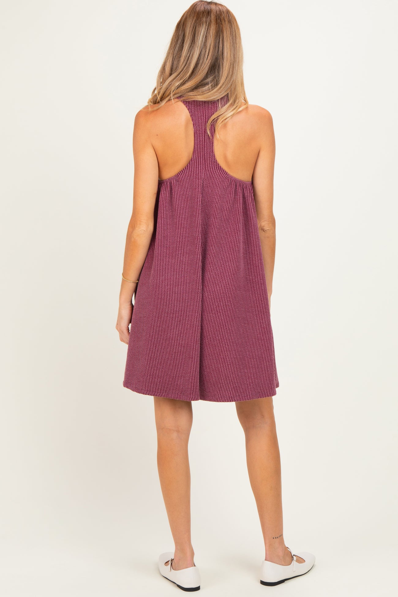 woman wearing a maroon striped sleeveless maternity dress with a relaxed fit and open back