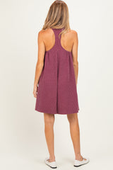 woman wearing a maroon striped sleeveless maternity dress with a relaxed fit and open back
