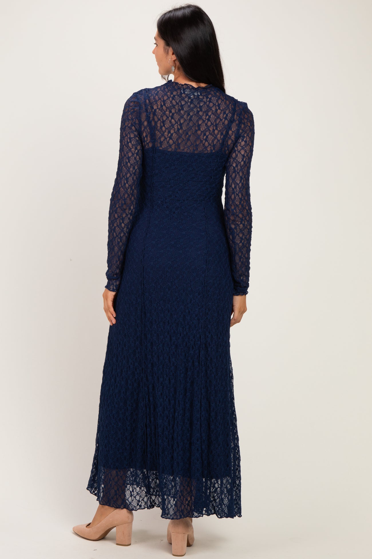 woman wearing a navy blue long sleeve lace maxi dress from the back, featuring a tiered skirt and a fitted bodice