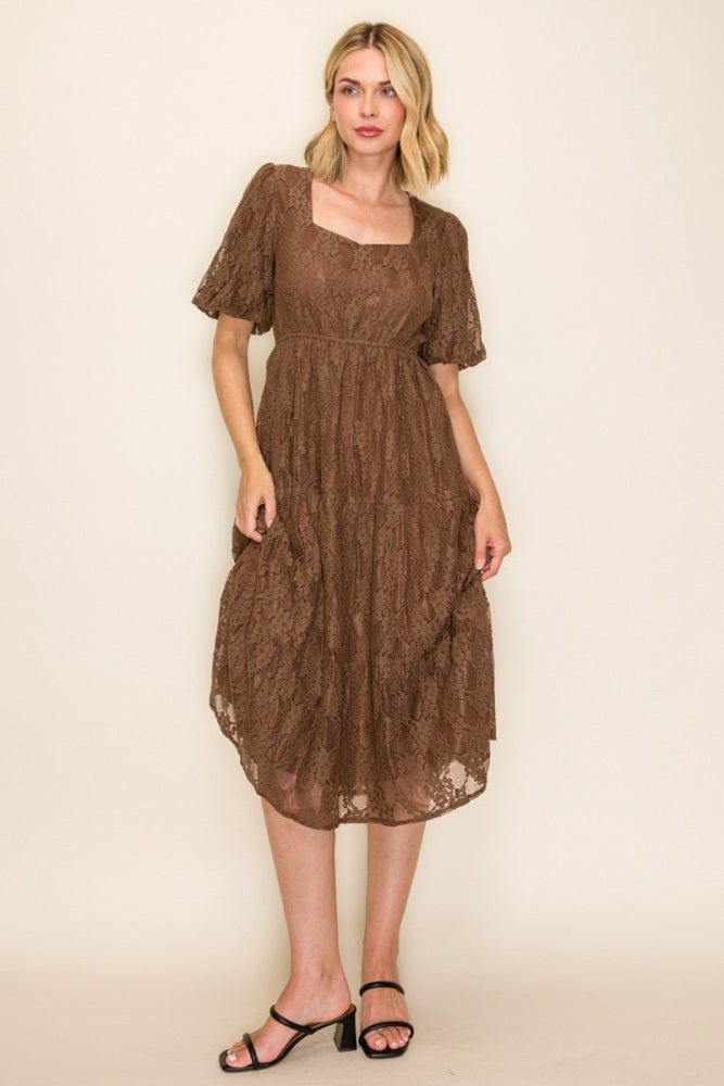 woman wearing a brown lace midi dress with short sleeves and a square neckline