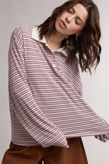 woman wearing a pink and white striped long sleeve polo shirt with a contrasting collar and relaxed fit