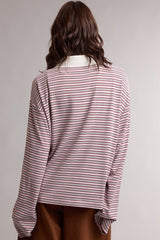 woman wearing a pink and white striped long sleeve top with a relaxed fit and wide sleeves, viewed from the back