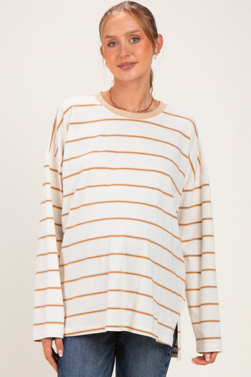 woman wearing a cream and caramel striped maternity top with a relaxed fit and visible baby bump