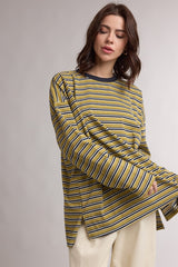 woman wearing a green and yellow striped long sleeve top with side slits and a relaxed fit