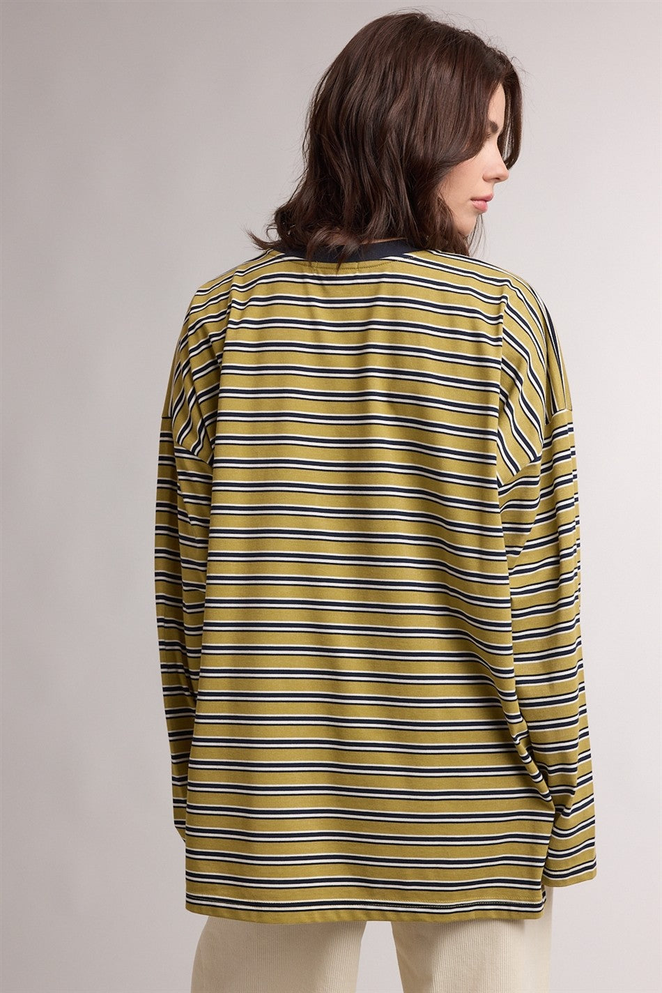 woman wearing a yellow and navy striped long sleeve top, viewed from the back