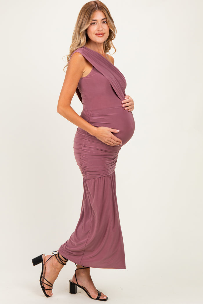 woman wearing a mauve one-shoulder maternity gown highlighting her baby bump