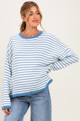 woman wearing a striped blue and white oversized maternity sweater with a relaxed fit and round neckline