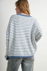 woman wearing a relaxed fit white and blue striped sweater with dropped shoulders and a round neckline, viewed from behind