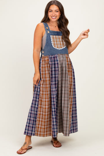 woman wearing a denim and plaid maternity dress with a fitted top and flowy skirt, showcasing a baby bump