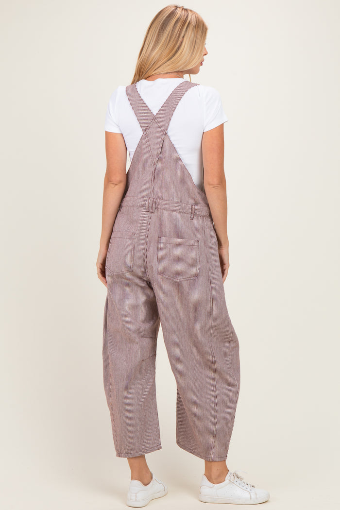 woman wearing striped overall pants with a white t-shirt, viewed from the back