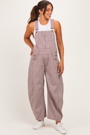 woman wearing a striped maternity overall with wide legs and a white tank top, styled with casual white sneakers
