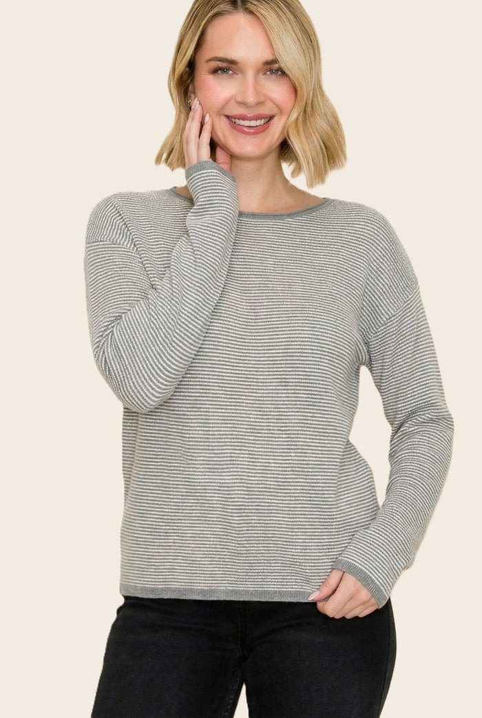 woman wearing a gray and white striped long sleeve sweater with a relaxed fit and round neckline