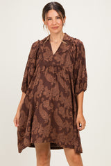 woman wearing a brown paisley print maternity dress with a v-neck and 3/4 sleeves, gently draping over her baby bump