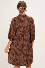 woman wearing a brown paisley print maternity dress with a loose fit and puff sleeves from the back