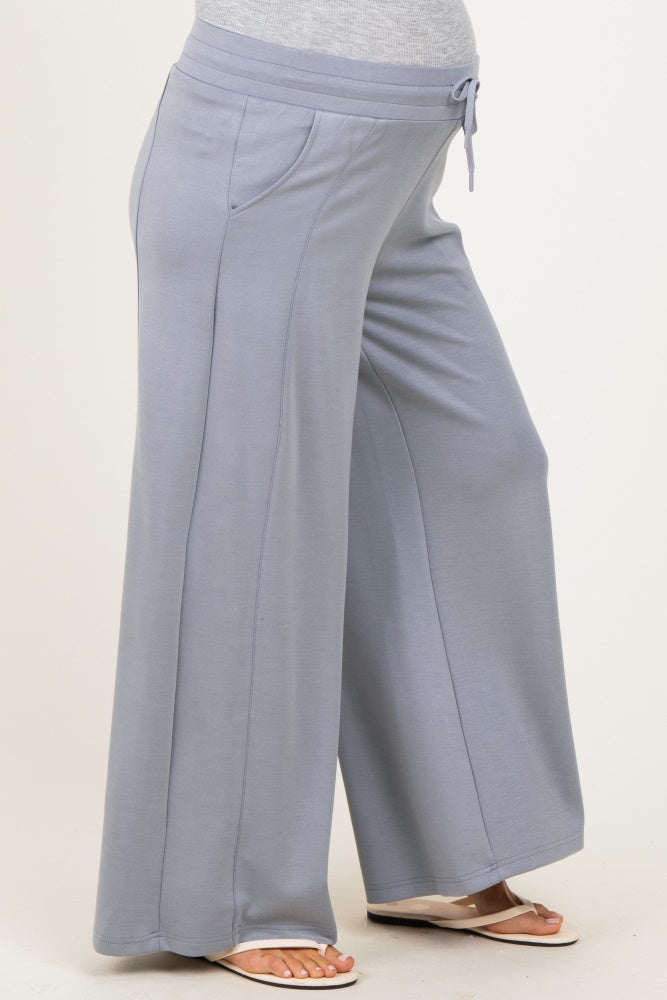 maternity wear light blue wide leg pants with a drawstring waist and side pockets, showcasing a visible baby bump