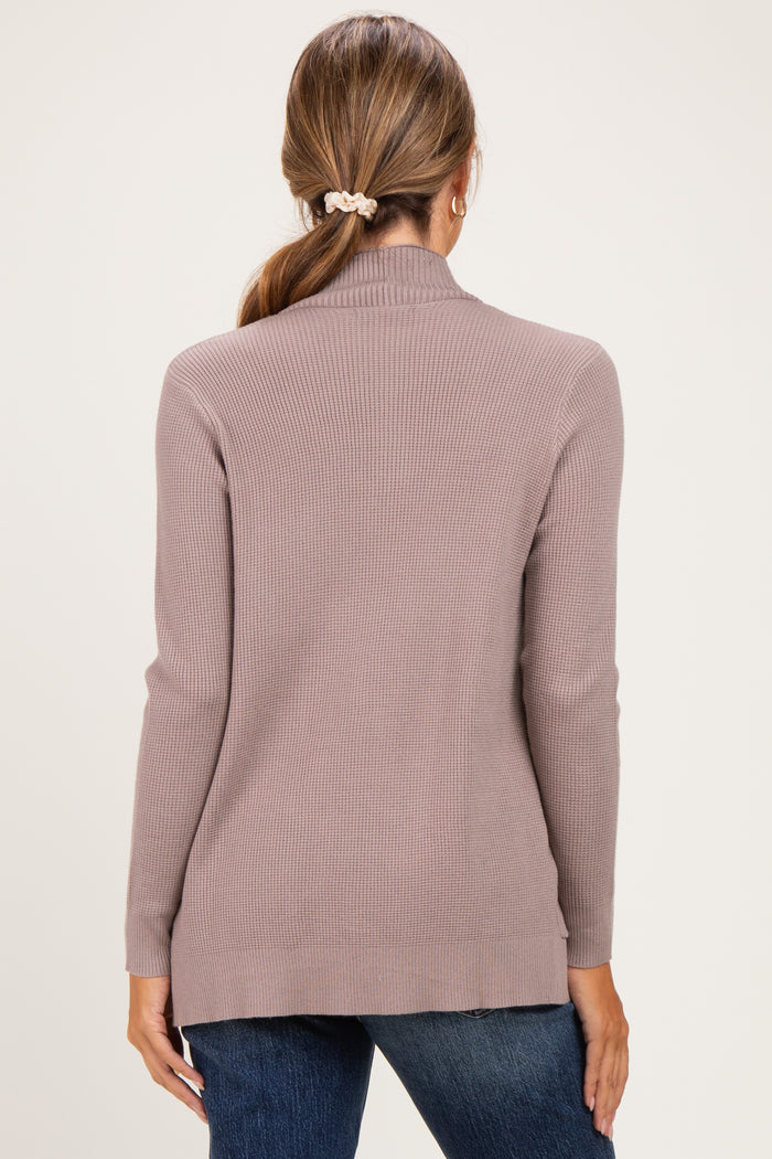 woman wearing a light taupe ribbed maternity sweater with a high neck and long sleeves, viewed from the back