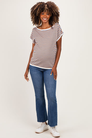 woman wearing a striped maternity top with short sleeves and blue jeans, showing her baby bump while smiling