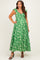 woman wearing a green floral maternity maxi dress with cap sleeves and a twist front detail, smiling and posing.