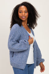 woman wearing a cozy blue oversized cardigan over a white top, styled with casual denim jeans