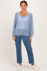 woman wearing a light blue open knit sweater and blue jeans with white sneakers