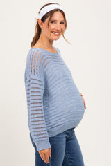 woman wearing a light blue maternity sweater with a relaxed fit and open knit pattern, showing her baby bump