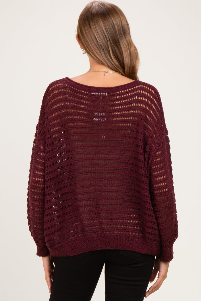 woman wearing a burgundy open knit maternity sweater with a relaxed fit and long sleeves, showcasing the back view