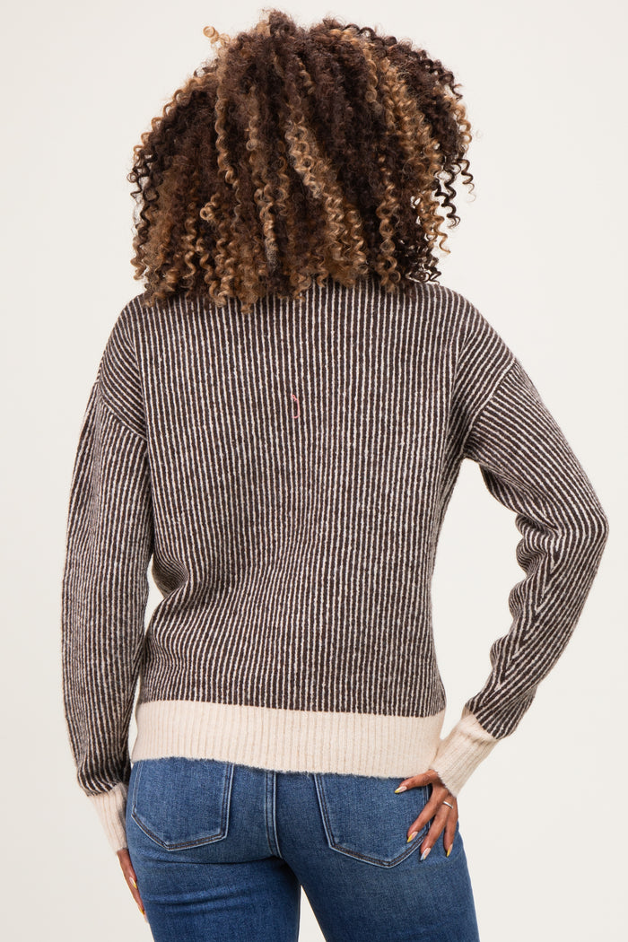woman wearing a striped maternity sweater in brown and cream, with a relaxed fit, showing her back and wearing jeans