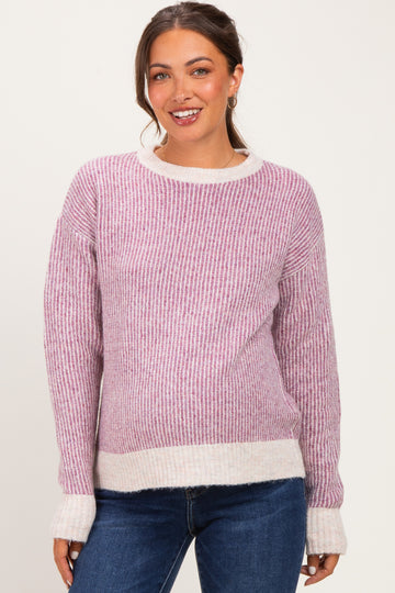 woman wearing a pink and white striped maternity sweater with a relaxed fit and ribbed texture