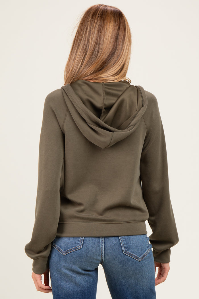 woman wearing a green maternity hoodie with a relaxed fit and back view, paired with blue jeans